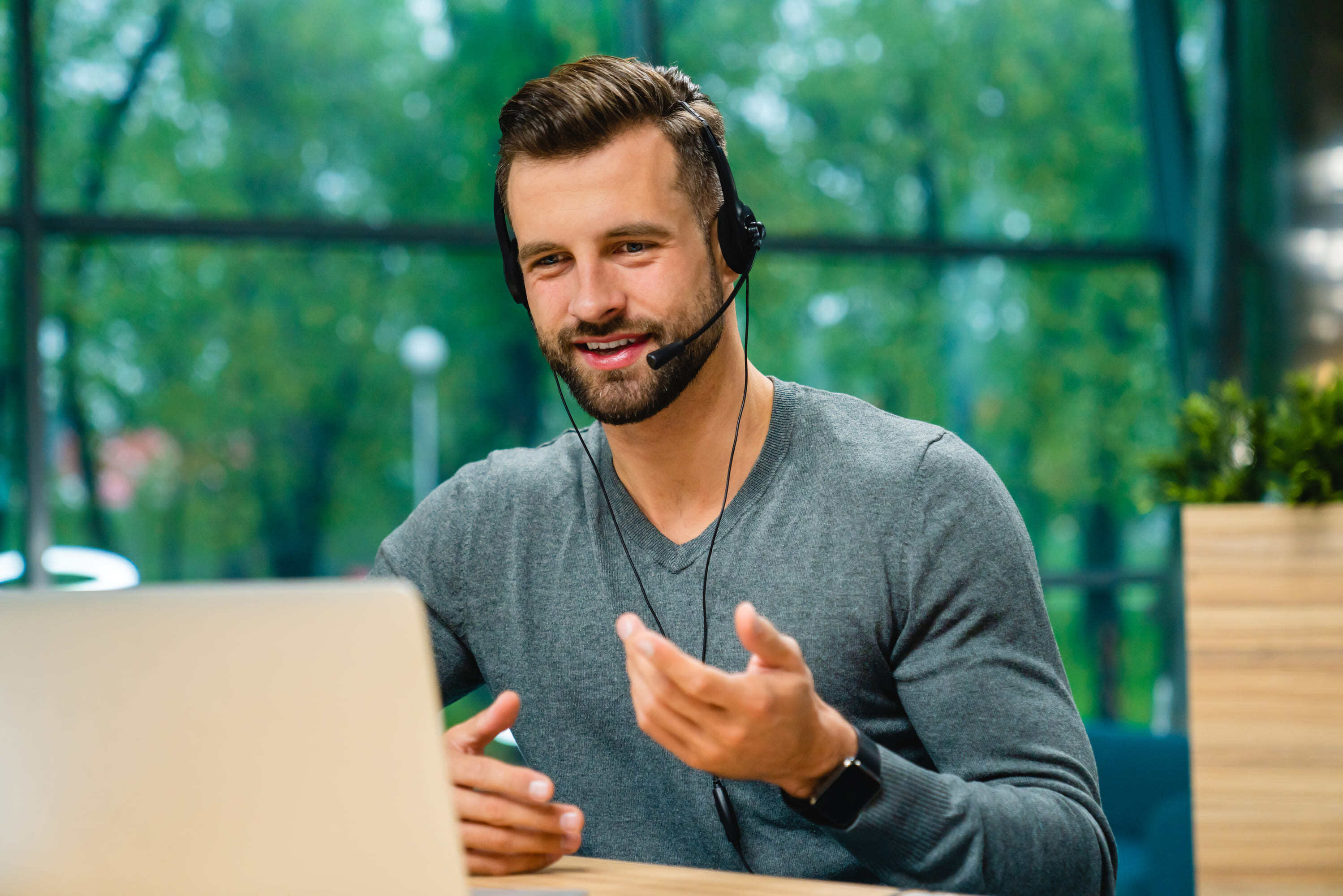 friendly-helpful-young-man-with-headset-explaining-2023-11-27-04-50-43-utc (1)